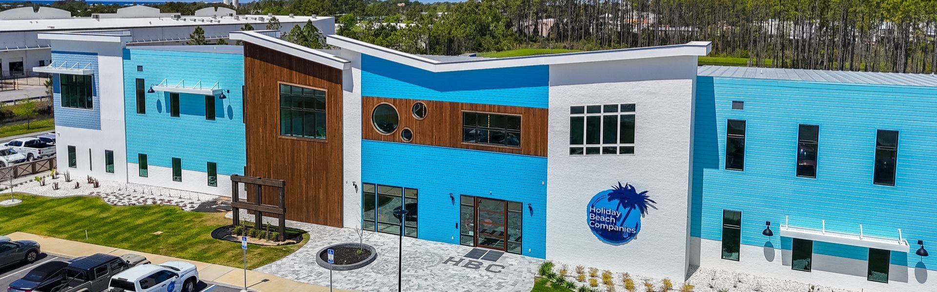 The blue and white Holiday Beach Companies headquarters, with HBC signage, at 151 Griffin Boulevard in Panama City Beach